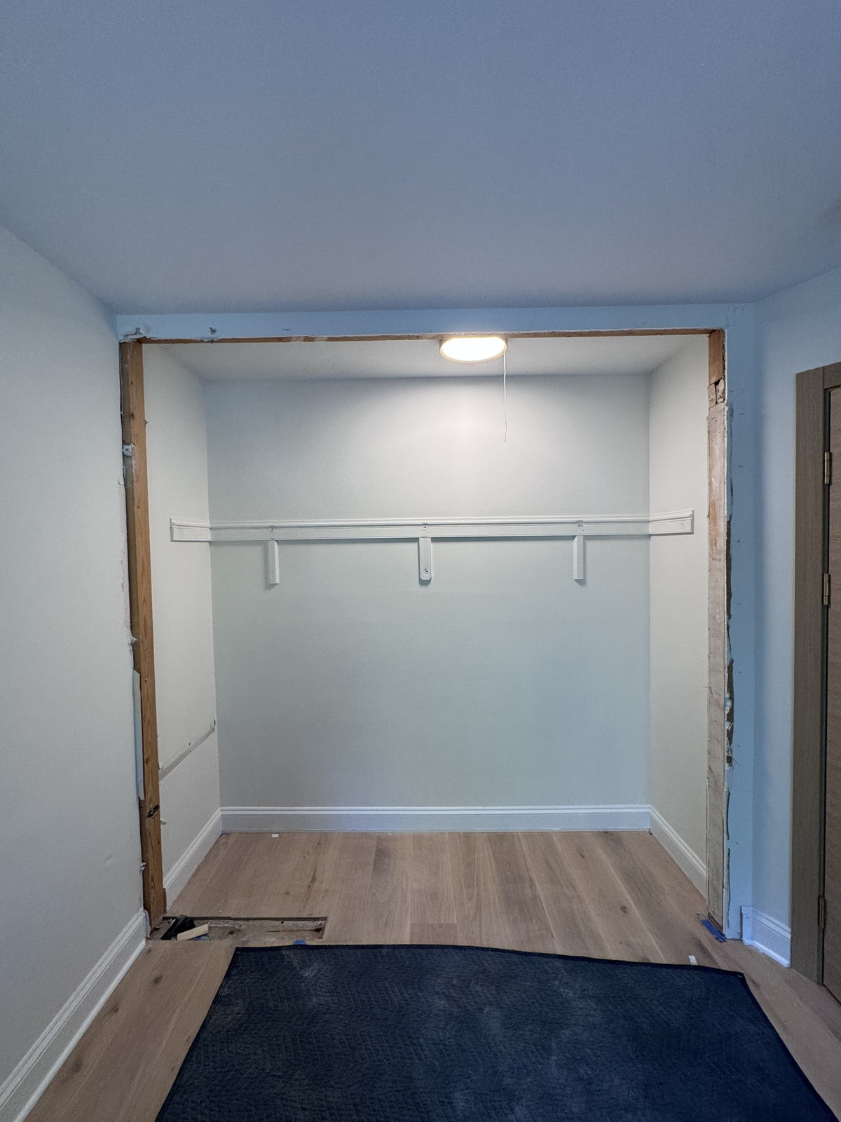 Before installation — original closet opening, shelf and hanging rod at this ModuCloset project.