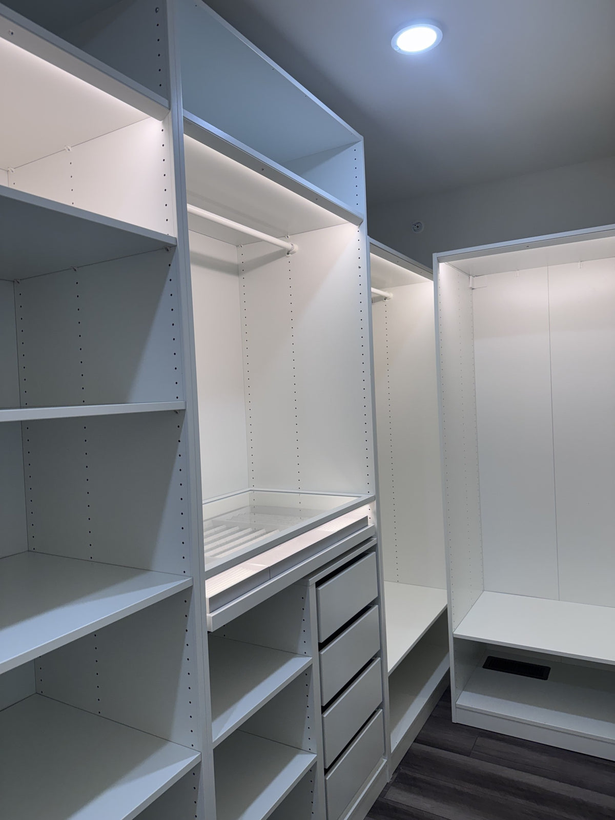 Real ModuCloset installation — angled view of illuminated hanging storage and shelves.