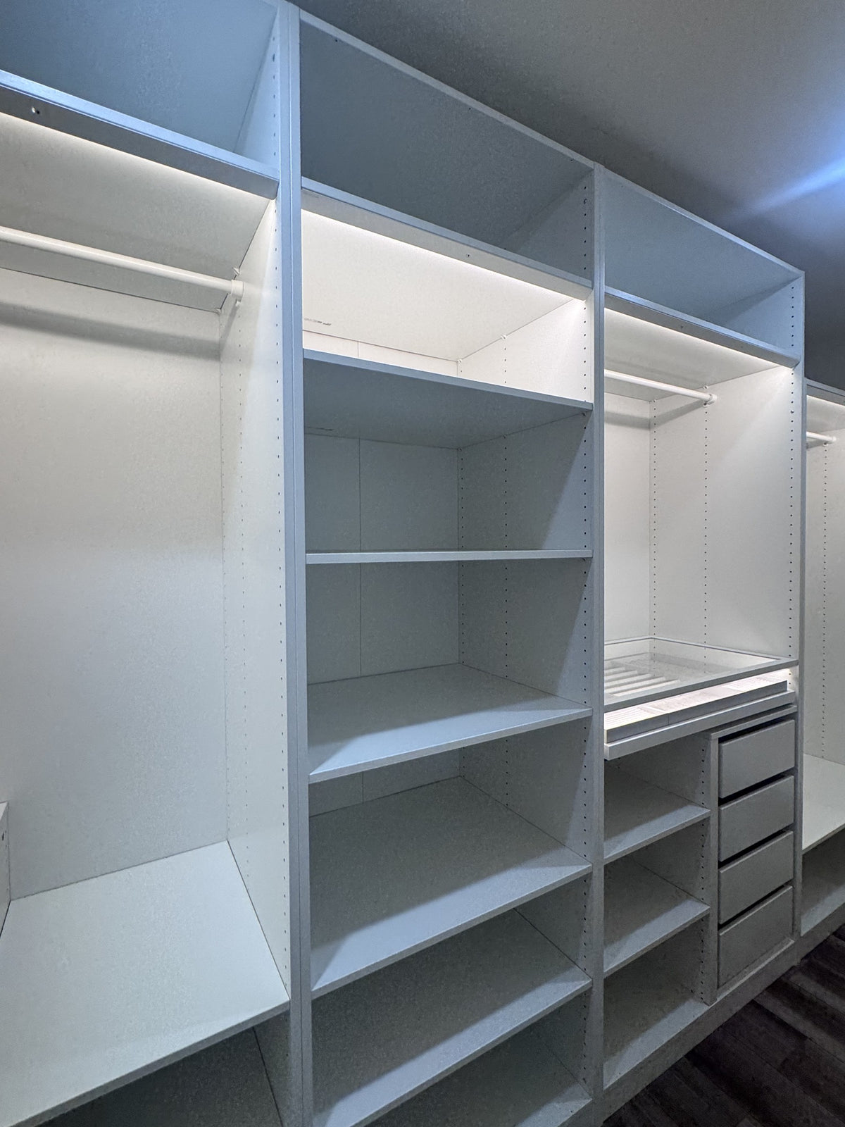 Real ModuCloset installation — LED-lit hanging bays beside shelves and drawers.