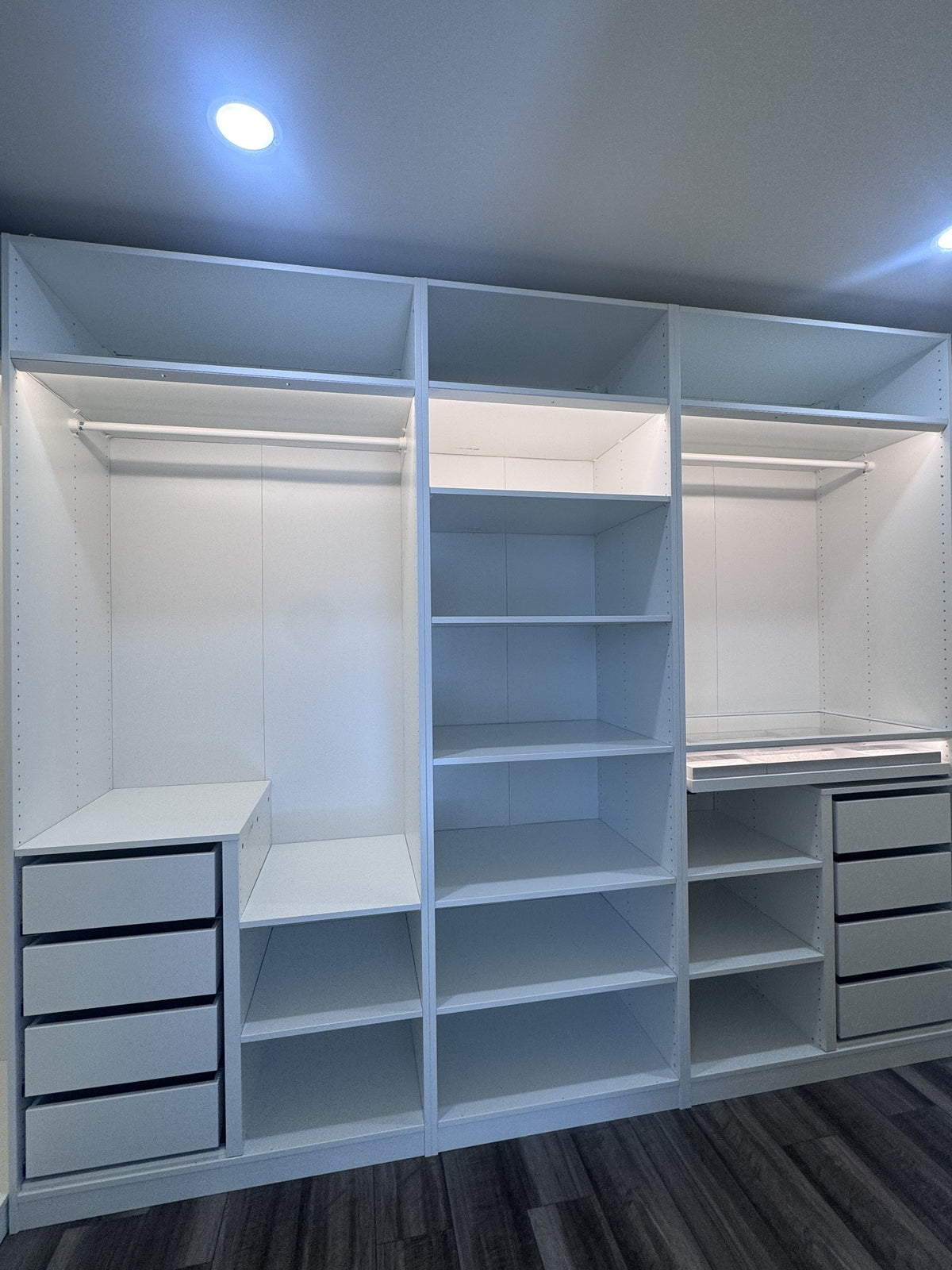 Real ModuCloset installation — frontal view of shelving and two drawer stacks in the walk-in closet.