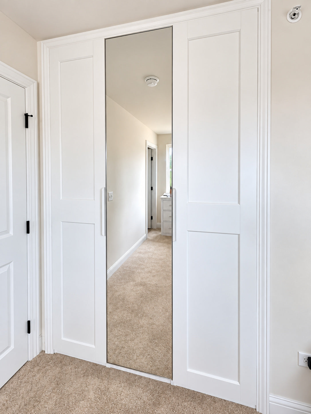 Real ModuCloset Project 4 — angled finished view of the white built-in closet with mirrored center door.